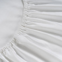 White fitted sheet corner with elastic ruffle edge and stitched seam detail