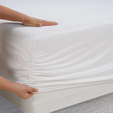 White fitted sheet with smooth top and gathered side seam, shown with hands