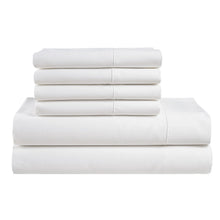 Stacked white cotton sheet set pieces with folded fitted sheet and pillowcases