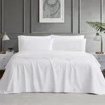 White sheet set on bed with fitted sheet, flat sheet, and pillowcases