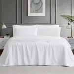 White sheet set with fitted and top sheets, neatly draped on bed