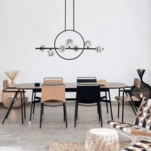Black circular LED island pendant light with horizontal bar and multiple glass globe bulbs
