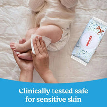 Huggies Natural Care baby wipes pack beside a baby during diaper change