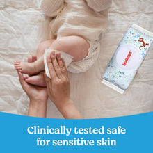 Baby wipes pack used during diaper change, with wipe pulled from the container