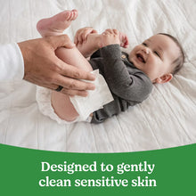 Sensitive baby wipes in use: adult wipes infant during diaper change