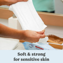Soft, strong wipes for sensitive skin, hand pulling a white wipe from the pack