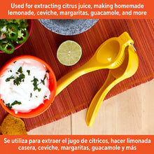 Yellow citrus juicer tool with curved press handles and straining cup