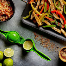 Green citrus squeezer on countertop beside lime halves