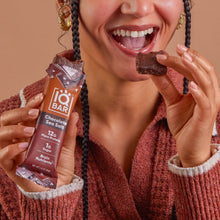 IQBAR protein bar in chocolate sea salt flavor held by a smiling person