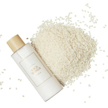 Toner bottle with gold cap next to scattered rice grains