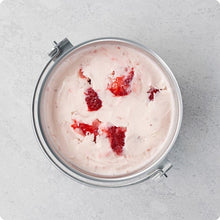 Ice cream churn bowl with red-flecked frozen mixture, inside the ice cream maker