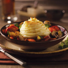 Prepared mashed potatoes in a bowl with vegetables and herbs