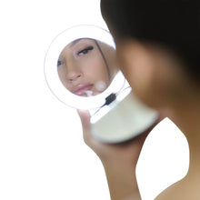 Ilios compact mirror held near face, circular glass reflecting a person
