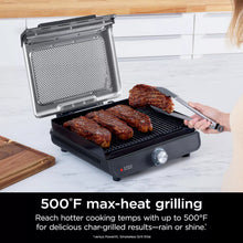 Indoor electric grill with open lid and searing plate holding grilled meat patties