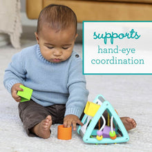 Child using teal and white activity triangle shape sorter with multicolor shapes