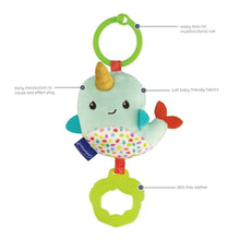 Narwhal plush clip-on toy with green ring, patterned belly, and yellow teether.