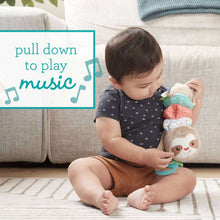 Toddler holding hanging plush sloth toy with colorful bands and teal teether