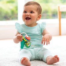 Baby holding the teal music-light key teether with red textured ring and hanging tags