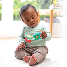 Baby playing with a teal music-light key teether and red textured ring