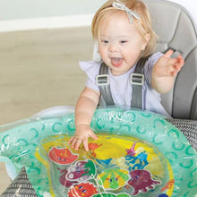 Baby playing on a narwhal-shaped teal tummy time play mat with sea animal figures