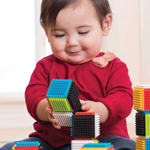 Stacking blocks set, multicolor stud cubes in a child’s hands during play