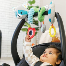 Plush raccoon spiral activity toy with leaf wing, ring mirror, bird rattle, and flower teether