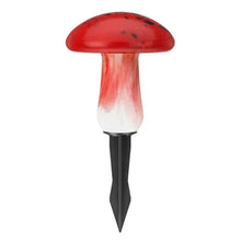 Red mushroom solar light with glowing white base and black pointed stake