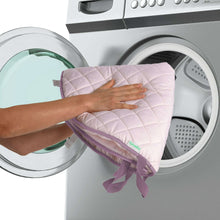 Reversible quilted duvet cover being held above a washing machine