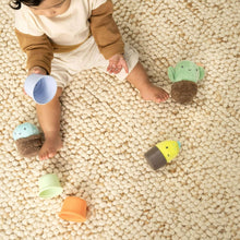Stackable nesting rattle cups with plush sea-creature heads; lime, orange, and blue
