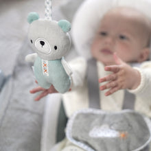 Plush bear toy and baby in automatic bouncer seat with gray and teal fabric