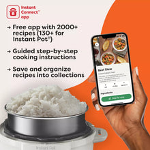 Electric pressure cooker with hand holding phone displaying guided recipe steps