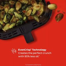 Brussels sprouts cooking in black air fryer basket with side handle