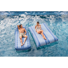 Two inflatable pool lounge chairs with white striped cushions on blue