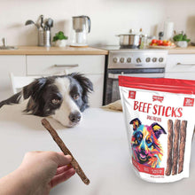 Dog sniffing a beef stick, with Irish Rover beef stick treats bag beside it.
