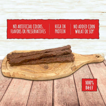 Beef stick dog treats with thick brown sticks on a wooden serving board.