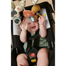 Baby playing with a farm spiral toy featuring plush animals, stars, and ring link