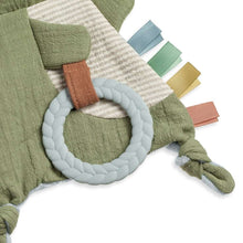 Olive crinkle dinosaur plush with white teether ring and striped hanging tags