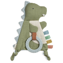 Green crinkle dinosaur plush with white teether ring and striped fabric tags
