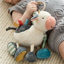 Plush cow activity toy with hanging ring and dangling colorful fabric pieces