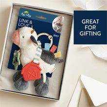 Plush cow activity toy in open gift box with red teether and hanging ring