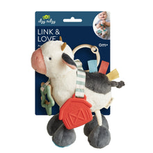 Plush cow activity toy in retail package, red teether and colored fabric straps