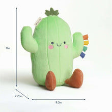 Green cactus plush toy with smiling face and multicolor ribbon arm details, with size guides