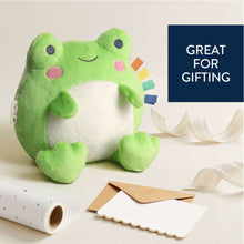 Green frog snuggle plush with white tummy, smiling face, and multicolor sensory ribbons