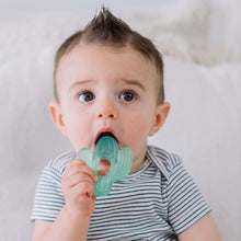 Baby holding green water-filled cactus teether with ring handle