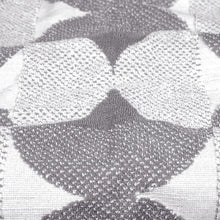Gray bath towel close-up with white and gray heart pattern, textured knit weave