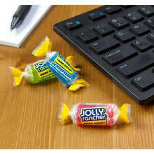 JOLLY RANCHER hard candy wrappers and wrapped candies on a wooden surface
