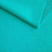 Jacquard kitchen towel, teal textured woven fabric, folded