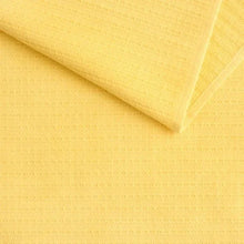 Jacquard kitchen towel, yellow textured woven fabric, folded