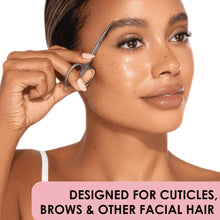 Facial hair trimming scissors held near the cheek with angled pointed blades