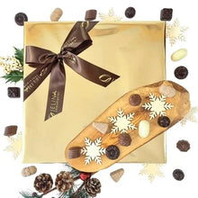 Chocolate gift box with gold wrapper and brown bow, with assorted chocolates scattered around